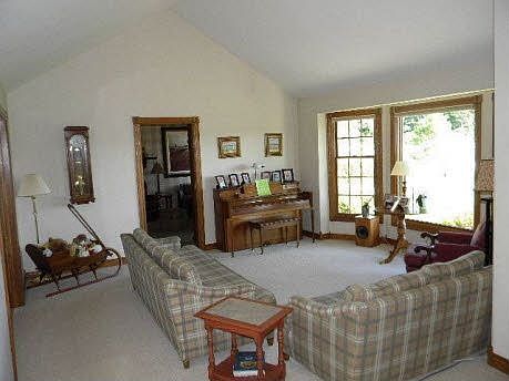 Living room with cathedral ceiling, looking into den