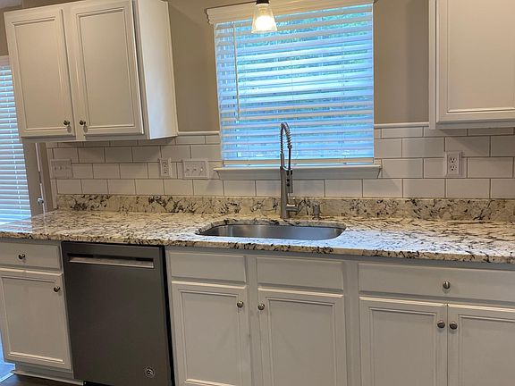 The kitchen features granite counter tops and stainless steel appliances.