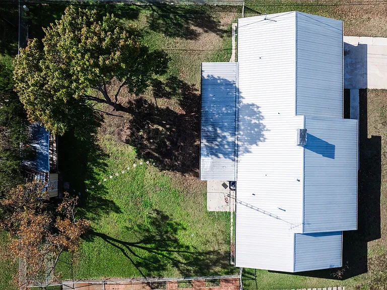 Aerial view showing the home's roof and side yard from above