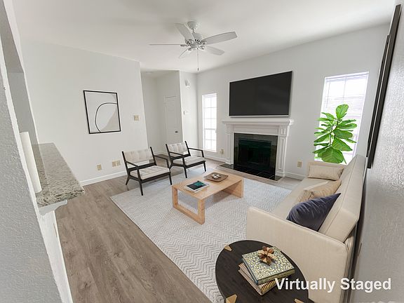 Living area with wood burning fireplace, ceiling fan