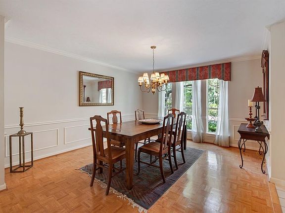 Elegant dining room with crown molding, chair rail, picture frame molding and timeless parquet flooring.