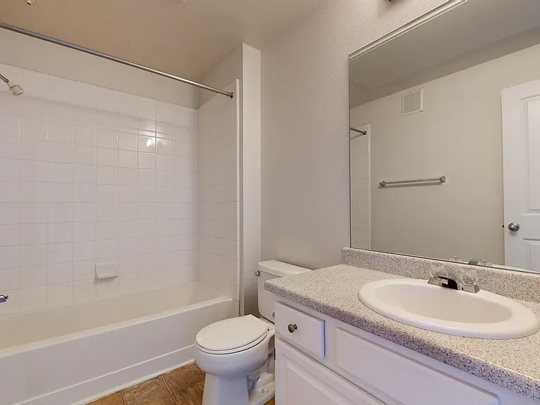 Apartment bathroom with large soaking tub, and wood-style flooring.