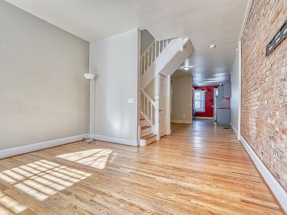 SPACIOUS LIVING RM w/WOOD FLRS & BRICK ACCENT WALL