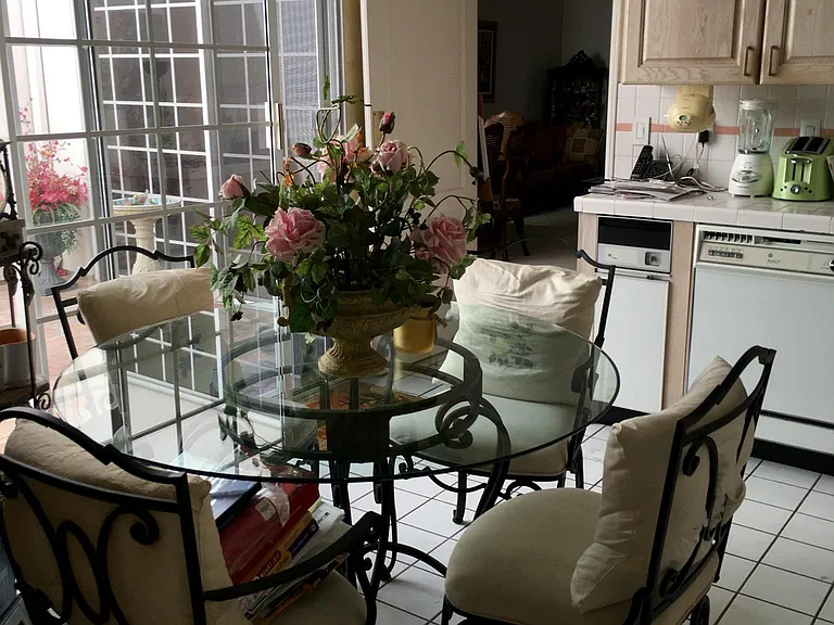 Seating Dinette Area In Spacious Kitchen Over Looking Large Patio Atrium, relaxing, and looking up to blue sky's.