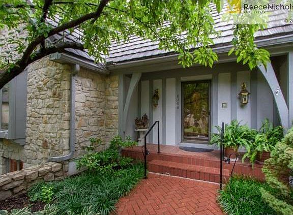 Welcome your guests with lush landscaping and a herringbone brick walkway and porch.
