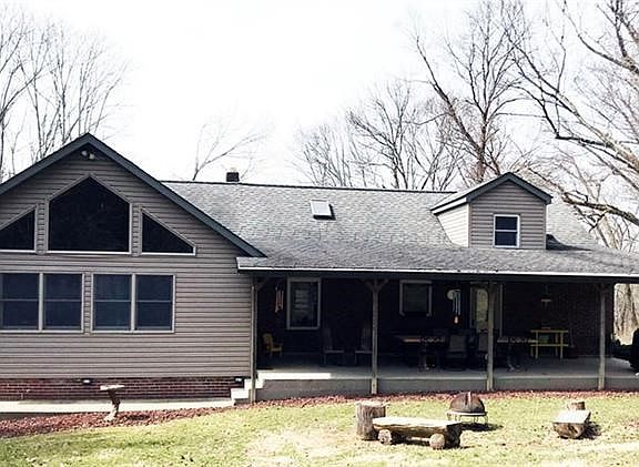 Rear of home facing the woods!  Large covered porch with access to the kitchen and living room.