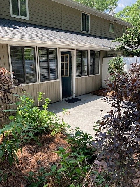 Back of unit with concrete patio, privacy fence and garden