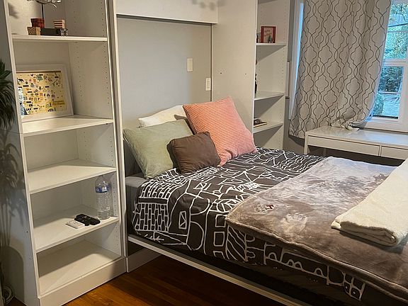 Furnished space with murphy bed that folds up and down as needed to create additional space.