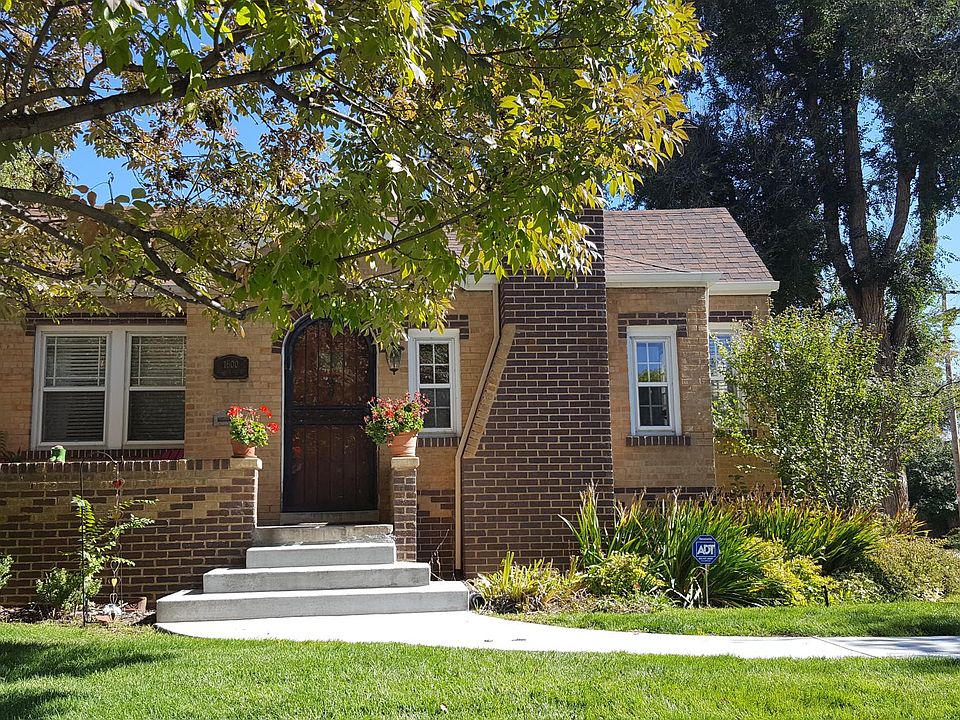 The property sits on a large corner lot, covered with beautiful mature trees, flowering bushes and irises. This is the front of the house.