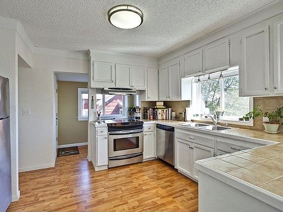 Newer stainless steel appliances, laminate flooring, tile counters and loads of cabinet space make t