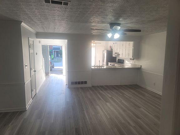 View from the sunroom looking into the open-concept living room and kitchen, showcasing the seamless flow of the first floor. The wide new granite countertop is perfect for casual dining_just add two bar stools!