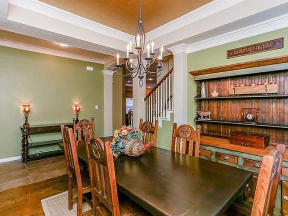 The dining room is spacious yet cozy, great for large gatherings or daily enjoyment.  Tray ceiling with double crown molding, accented by an elegant with designer chandelier.
