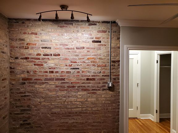 7234-2N: Exposed brick wall with track lights and walk-in closet