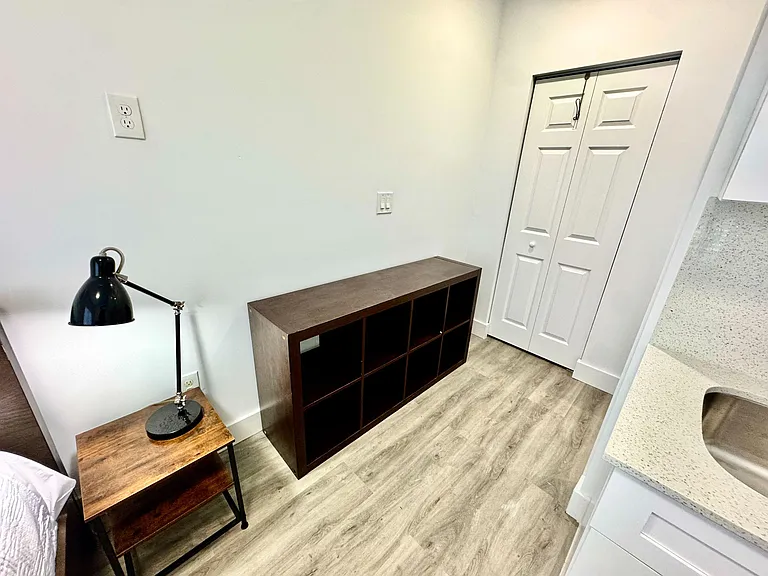 Bedroom area with a built-in style vanity counter, ample outlet access, and a double-door closet for convenient storage.