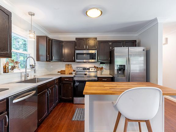 The kitchen has beautiful dark wood cabinets. The island is not stationary and will not be present upon moving in.