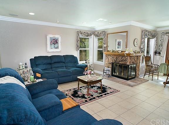 The cozy family room with tile floors, a fireplace, recessed lighting, crown moldings, upgraded window casing & sill.