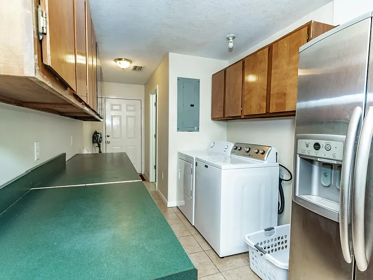 Laundry room with washer, dryer, iron and ironing board. Half bath with utility tub.