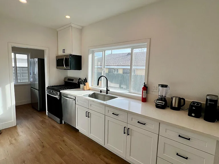 Kitchen equipped with dinnerware, blender, electric kettle, toaster, and keurig