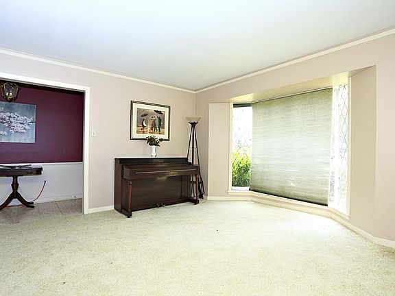 Foyer with terrazzo tile and spacious formal living with leaded glass bay window that provides great