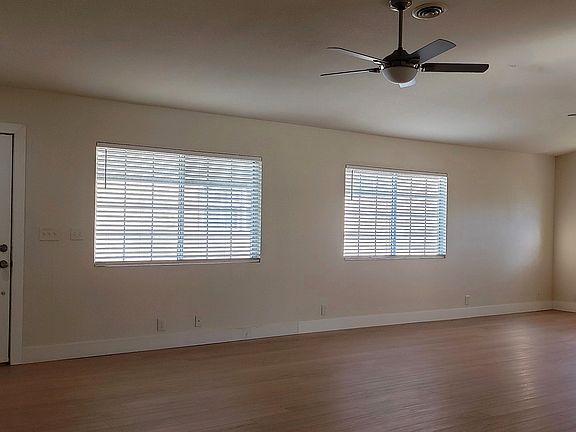 Great Room 1: Shows new luxury vinyl flooring, faux wood blinds, and new brushed nickel fans.