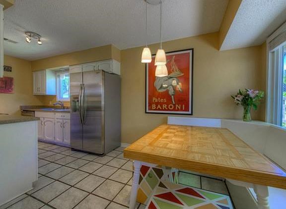 Galley kitchen with eat in dining features painted cabinets with new hardware, updated counters, sin