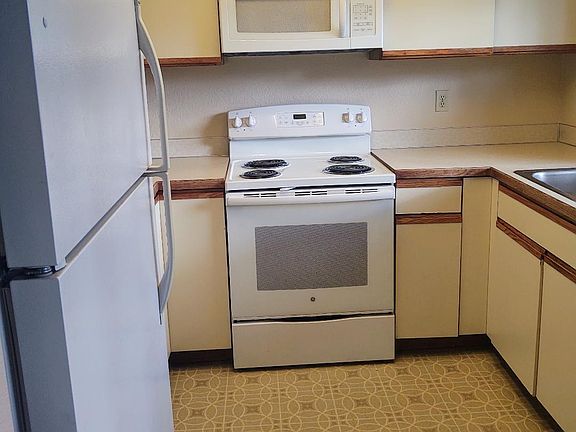U shaped kitchen has a large garden window over the sink and a pass through counter space to dining area.