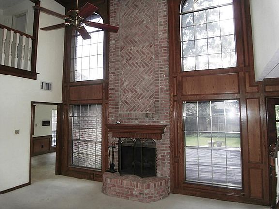 DEN WITH TALL CEILING, WOOD BURNING FIREPLACE, AND BEAUTIFUL VIEW OF BACK YARD