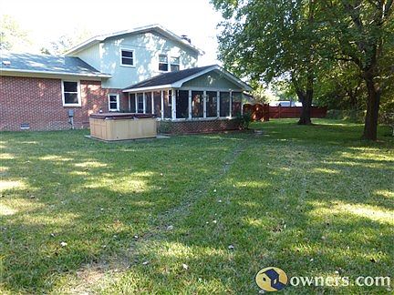 Backyard view of hot tub and screened in porch