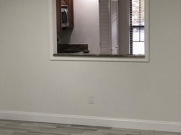 Large pass-thru into kitchen showing kitchen window and full sized washer dryer in kitchen closet.