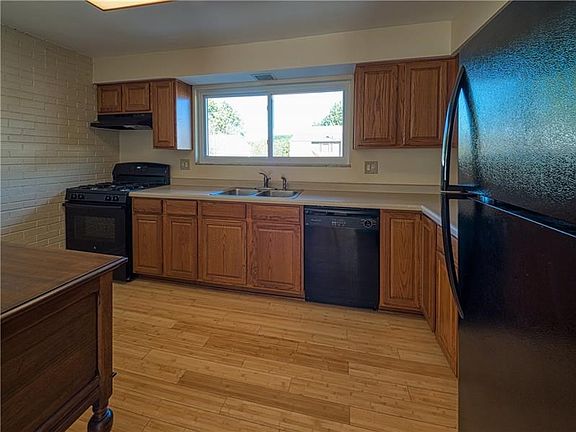 The expansive kitchen features a bright window and hardwood flooring.