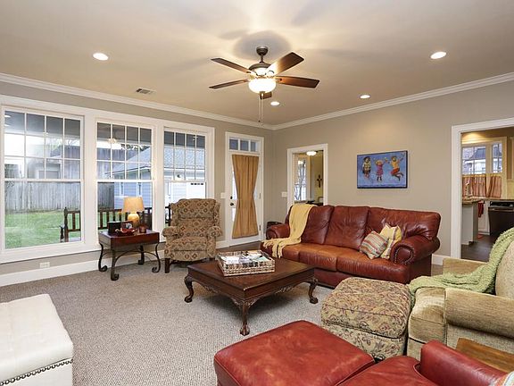 Family room/ den with wall of windows overlooking brick paver patio and large backyard