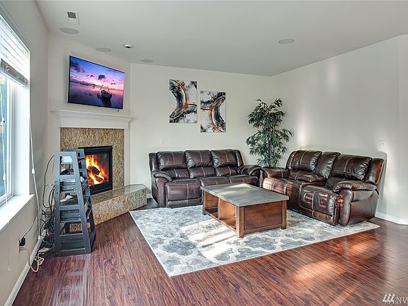 Spacious living room adorned with striking granite surround corner fireplace.