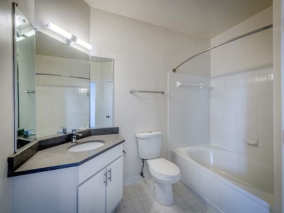 Renovated Package II bathroom with white cabinetry, grey quartz countertop, and hard surface flooring