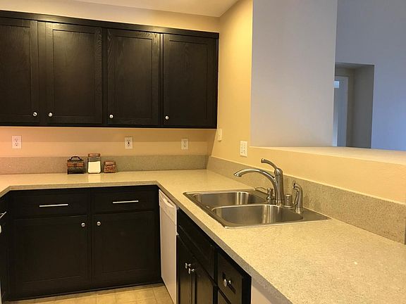 The kitchen faces the living room and dining room. The floor_ has been updated to grey vinyl tiles.