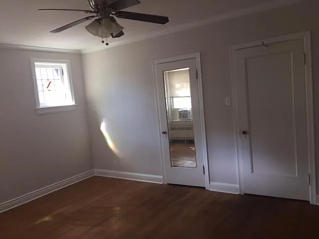 Large bedroom with crown molding, stained glass, and ceiling fan