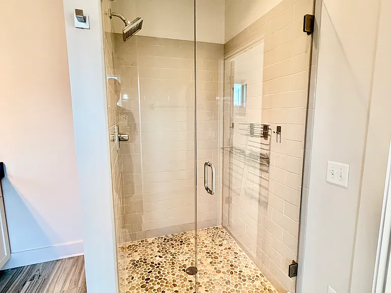 Glass enclosed shower with pebble flooring