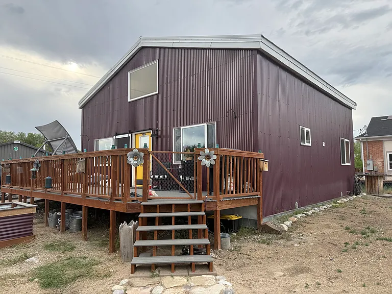 Additional entry with steps to fenced in porch with porch swing and gas grill