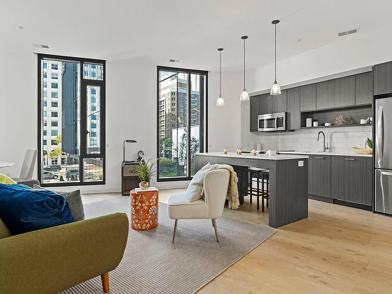 Bright, spacious living areas with floor-to-ceiling windows with natural wood flooring throughout