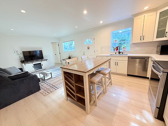 Spacious dining island with seating and built-in wine and spice storage, connecting the kitchen and living area, with direct access to the private patio.