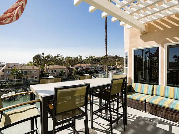 The spacious private deck offers stunning views of the Lagoon and marina. It features a built-in BBQ, an outdoor dining area, and comfortable sofas, perfect for relaxing and soaking up the sun.