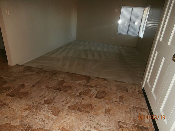 Entry looking into living room. Carpet shown has been replaced with wood-like tile. All flooring is tile.