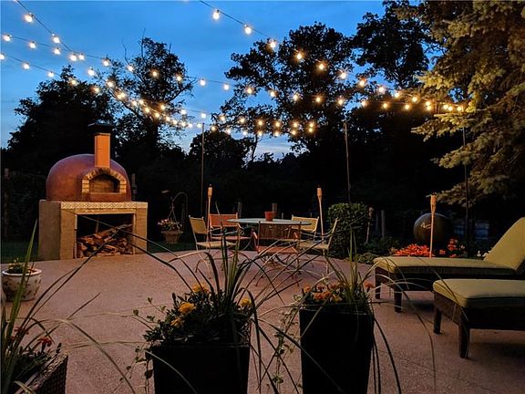 A little oasis right in your own backyard as you step down from the covered deck (left)!  Large new patio with brick oven!  Larg