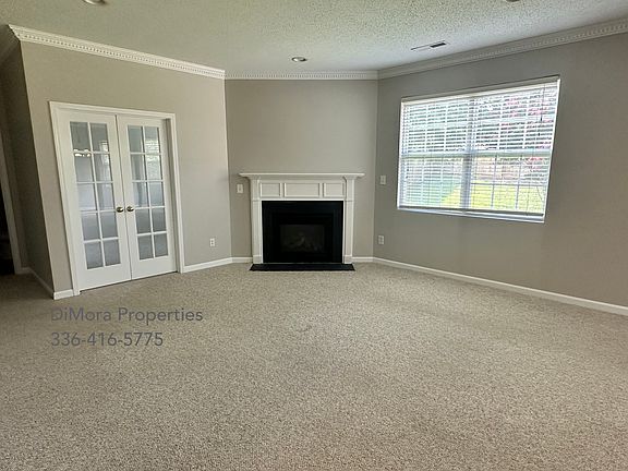 Living room with fireplace. French doors lead to office.