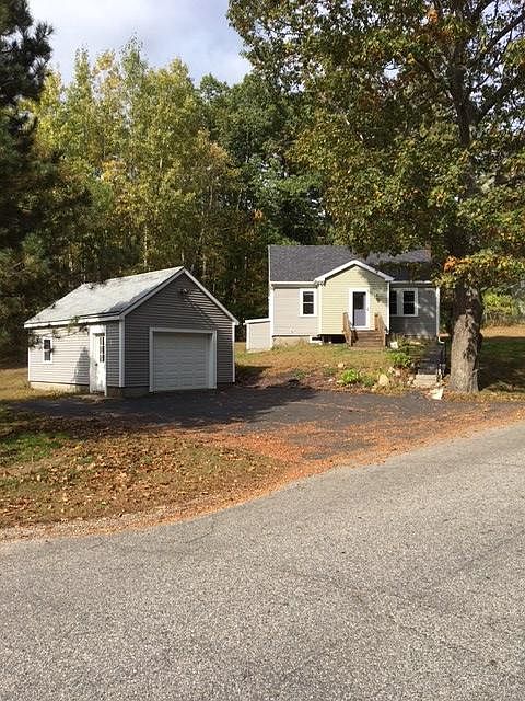 Street view of house with detached garage, on one acre of land.