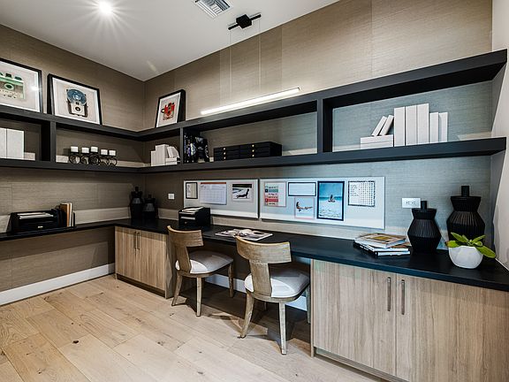 A modern and well-organized home office space with wooden furniture, shelves, and various decorative