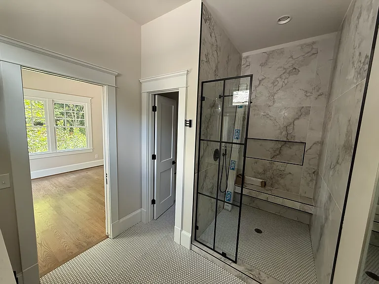 Master bath that still needs the shower door installed. Bidet closet door is open