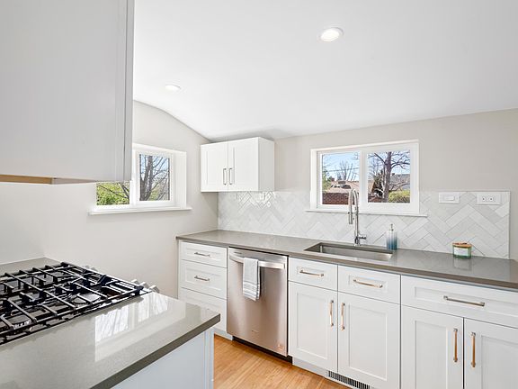 New kitchen with all new appliances (gas range and quartz countertops). Kitchen in back behind living room and dining room with door to backyard and basement off the kitchen.