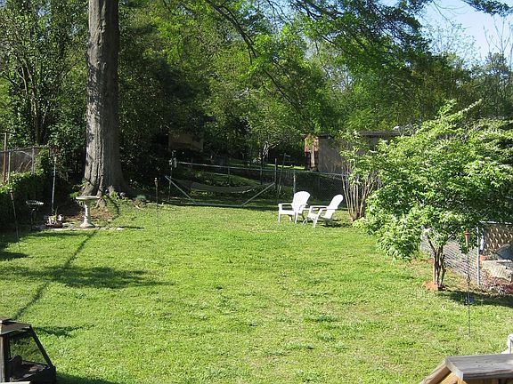 large, fully fenced backyard with grand 100 year old oak tree