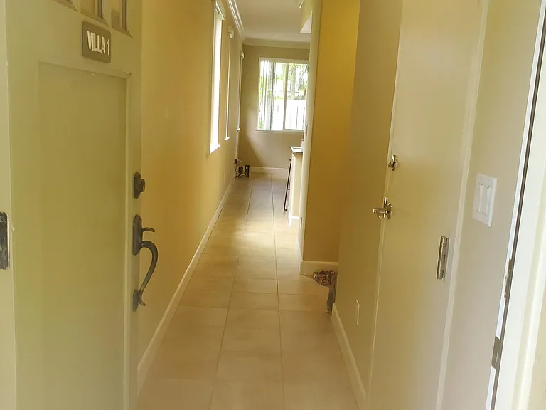 Hallway leading to living room and garage entry door