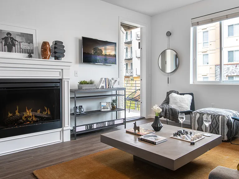 Apartment living room with wood-style flooring, fireplace and balcony.